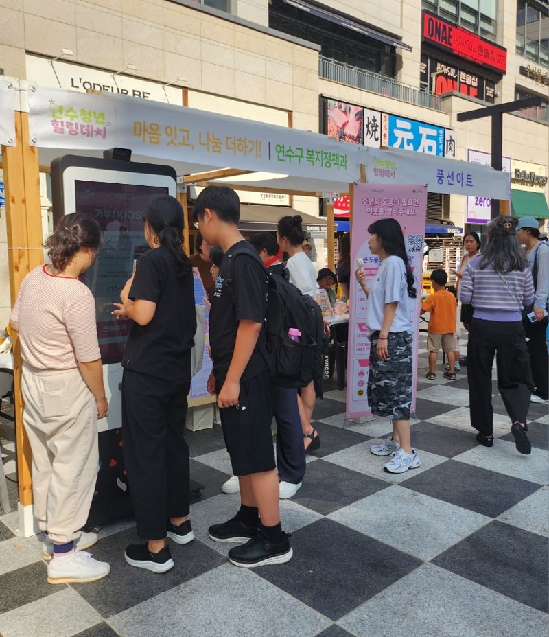 주민들이 행사장에서 복지위기 알림 앱 가입과 기부 키오스크 체험 등에 참여하고 있다.