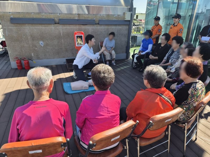아리마을 경로당에서 어르신들이 소방서 관계자의 지도에 따라 소화기 사용법을 체험하고 있다.