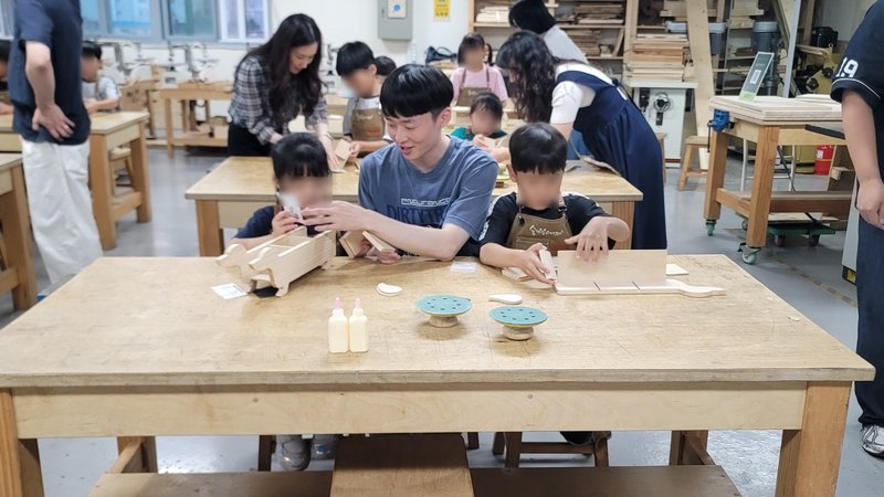 보라매보육원 아동들이 숭의목공예센터에서 목공예 전문 강사의 안내를 받아 닥스훈트 모양 수납 상자를 만들고 있다.