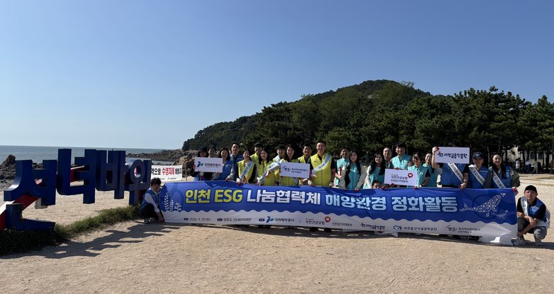 선녀바위 해변에서 인천 ESG 나눔협력체 참여기관 임직원들이 해양정화활동을 마치고 기념촬영을 하고 있다.
