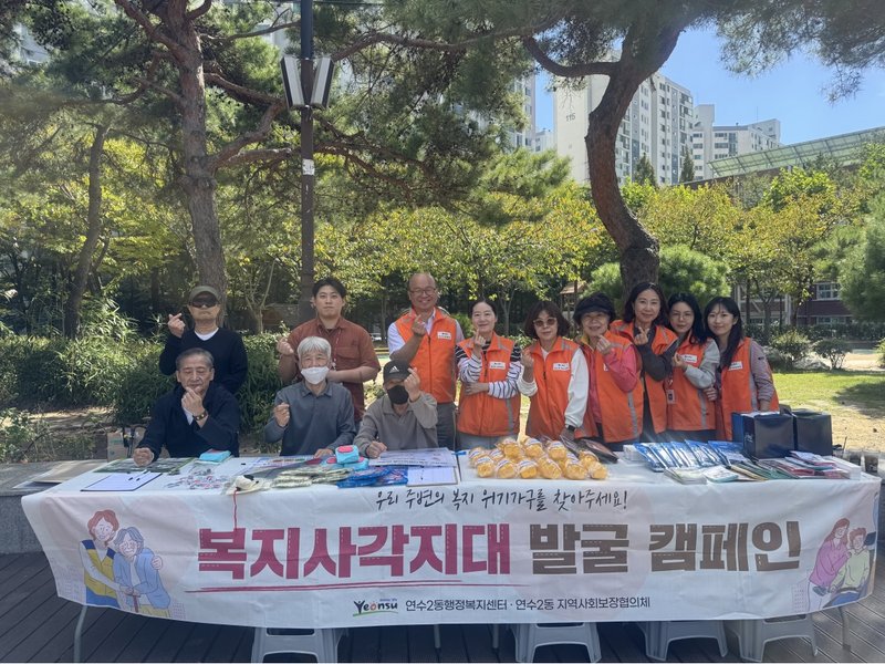 연수2동 지역사회보장협의체 위원 등이 솔안공원에서 주민에게 복지사업 안내문과 홍보 물품을 전달하며 복지 사각지대 발굴을 알리고 있다.