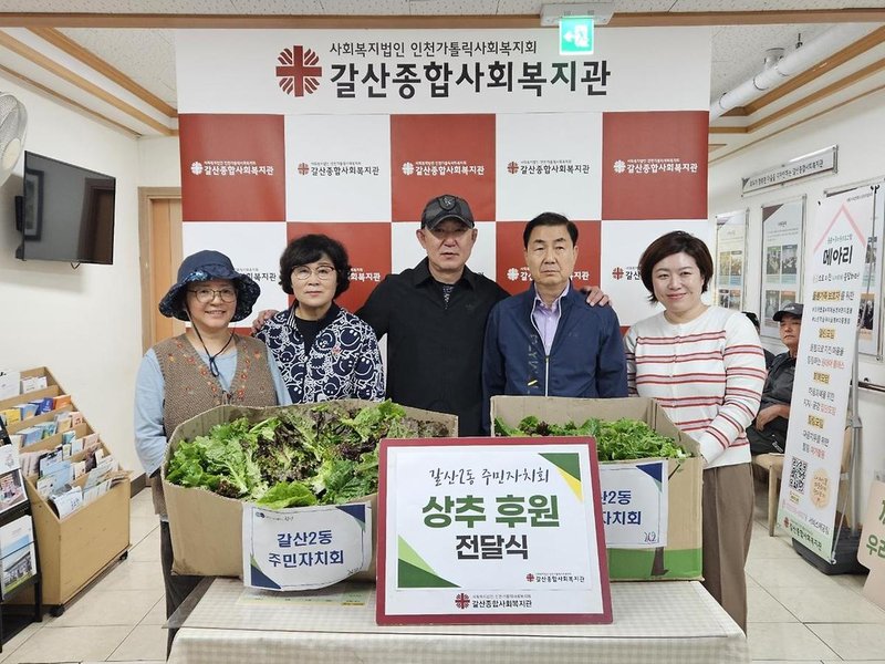 갈산2동 주민자치회가 옥상텃밭에서 수확한 상추를 갈산종합사회복지관에 전달하고 있다.