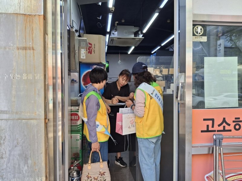 동춘2동 지역사회보장협의체 위원들이 상가 관계자에게 ‘착한가게’ 정기 후원 참여를 안내하고 있다.