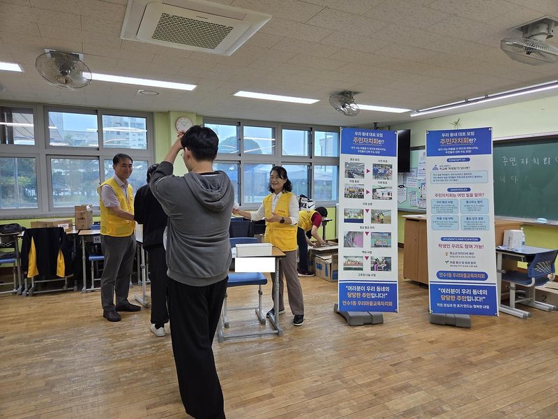 만성중학교 축제에서 학생들이 주민자치회와 우리마을교육자치회 관련 퀴즈 행사에 참여하고 있다.
