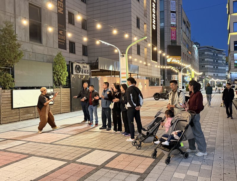 운서동 외국인 특화거리에서 아티스트 기타로로가 루프스테이션을 활용해 연주하고 있다.