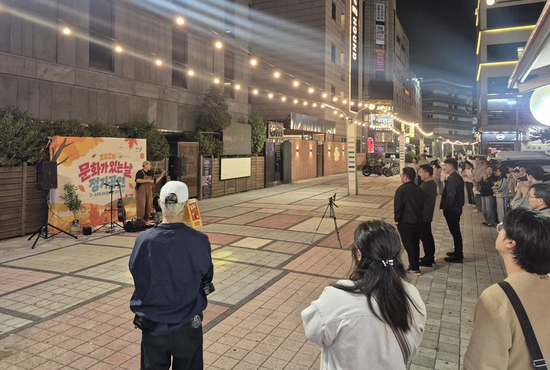 퇴근길 주민과 방문객이 거리 공연을 지켜보고 있다.