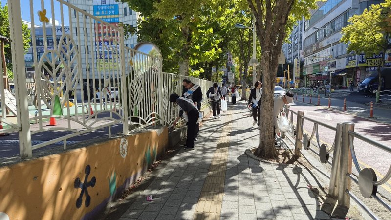 교직원들이 보행로 주변을 걸으며 생활 쓰레기를 수거하고 있다. 인천시교육청 제공