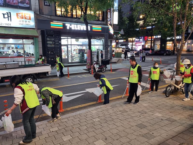 가을꽃 전시회 행사장 일대에서 봉사자들이 걸으며 환경정화 활동을 하고 있다.