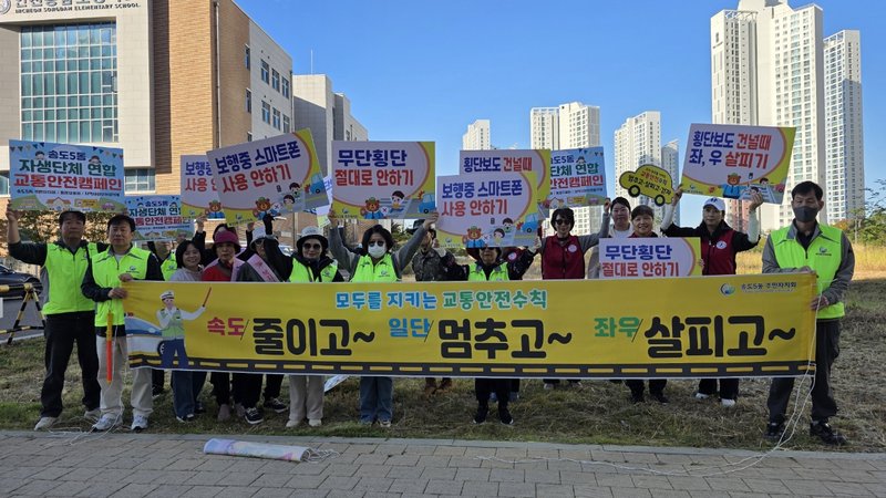 송도5동 주민자치회와 자생 단체 회원들이 송담초 사거리에서 등교하는 어린이들의 교통안전을 지도하고 있다.