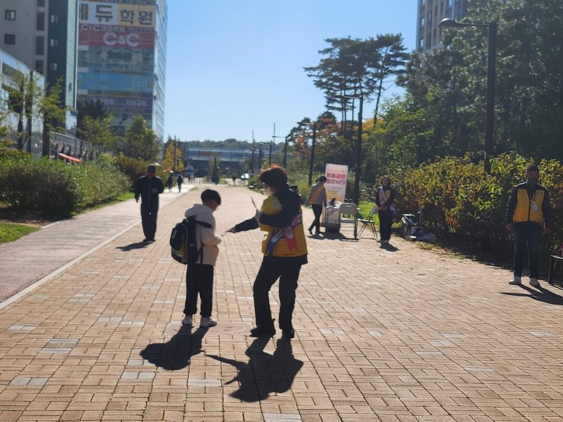 아파트 사잇길에서 금연 피켓과 홍보물로 금연 홍보 활동을 하고 있다.