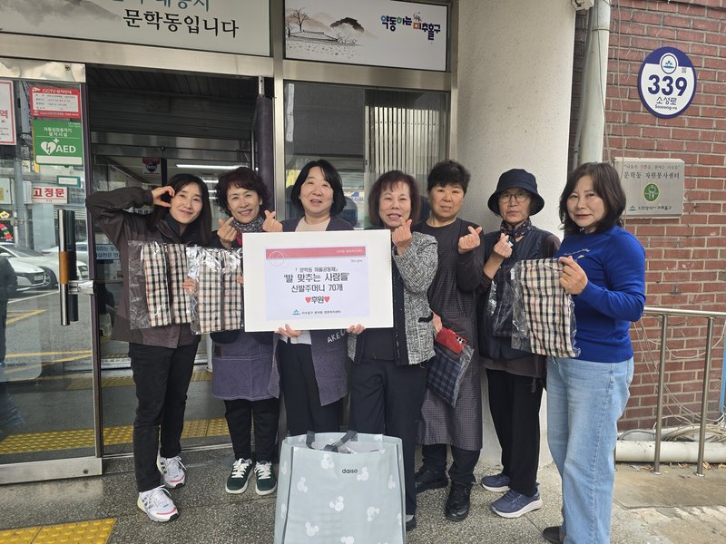 '발맞추는 사람들' 회원들이 문학동 행정복지센터에 기부한 신발주머니를 선보이고 있다. 미추홀구 제공